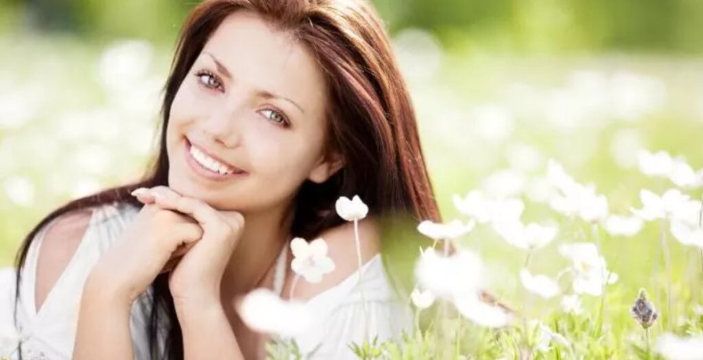 A beautiful woman with long brown hair and white flowers.