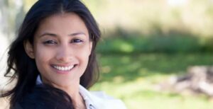 A woman smiling with her teeth showing.