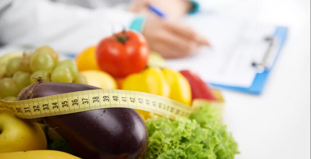 A close up of vegetables and fruits with a measuring tape