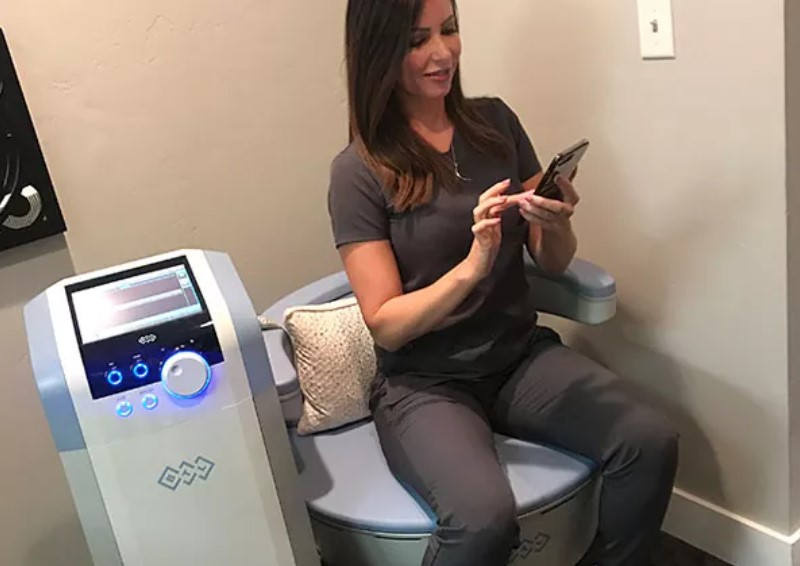 A woman sitting on top of a toilet holding her phone.