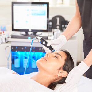 A woman getting her face cleaned by an esthetician.