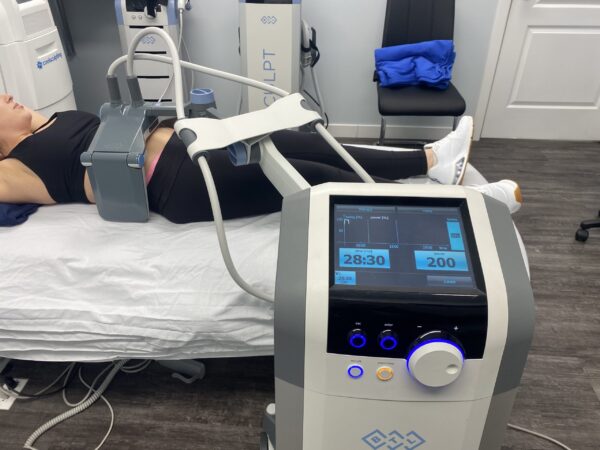 A person is lying on the bed with an ultrasound machine.