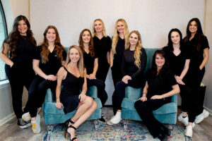 Group of women in black clothing smiling.