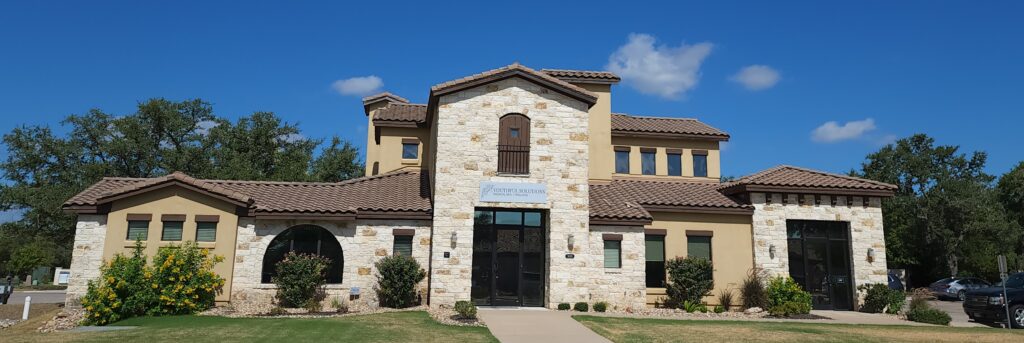 Stone building with a business sign.